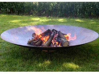 a grill with a fire in the grass at Time Out Beach House in Zandvoort