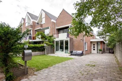 a large brick house with a driveway in front of it at Time Out Beach House in Zandvoort