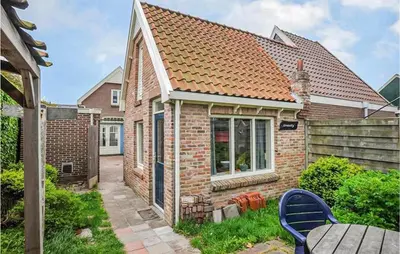 a brick house with a table and chairs in the yard at Duinviooltje 2 in Bergen aan Zee