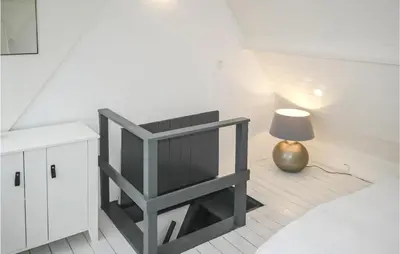 a living room with a chair and a lamp at Duinviooltje 2 in Bergen aan Zee