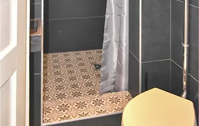 a bathroom with a shower with a yellow toilet at Duinviooltje 2 in Bergen aan Zee