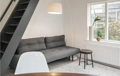 a living room with a couch and a staircase at Duinviooltje 2 in Bergen aan Zee