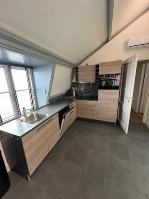 a large kitchen with wooden cabinets and a sink at Appartement Warmond in Warmond