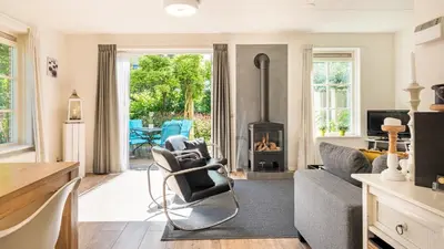a living room with a couch and a fireplace at Huisje Avondrood in Schoorl