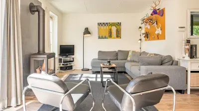 a living room with a couch and a fire place at Huisje Avondrood in Schoorl