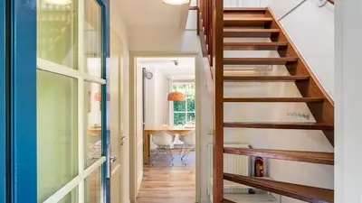 a staircase leading up to a home office with a desk at Huisje Avondrood in Schoorl