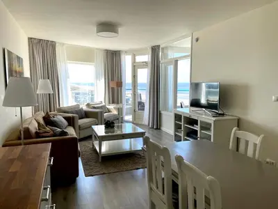 a living room with a couch and a table at Droomvakanties Egmond Zeezicht in Egmond aan Zee