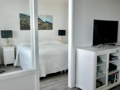 a mirror reflecting a bedroom with a bed and a television at Droomvakanties Egmond Zeezicht in Egmond aan Zee