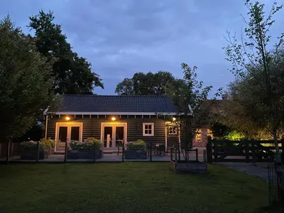 a house with lights on the front of it at Flora’s B&B in Landsmeer