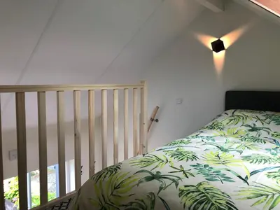 a bedroom with a bed with a green blanket at Flora’s B&B in Landsmeer