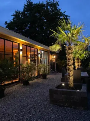 a building with a palm tree in front of it at Flora’s B&B in Landsmeer
