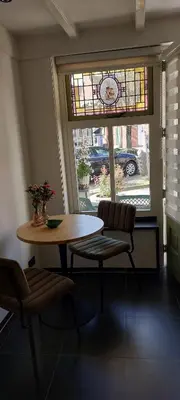 a table and chairs in a room with a window at Zeelucht in Zandvoort