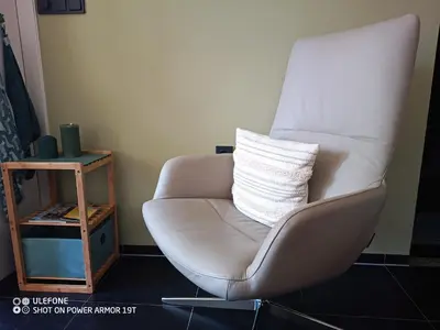 a white chair with a pillow in a room at Zeelucht in Zandvoort