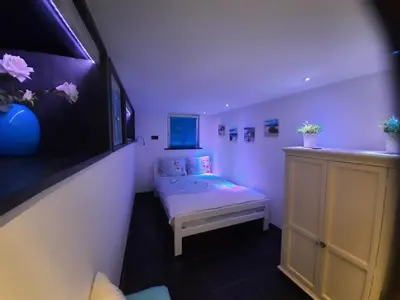 a small room with a small bed and a tv at Zeelucht in Zandvoort