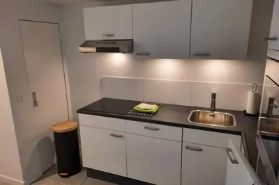 a kitchen with a sink and a counter top at Have a nice stay! - Souterrain Edelweiss in Noordwijk