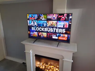 a flat screen tv on top of a fireplace at Have a nice stay! - Souterrain Edelweiss in Noordwijk