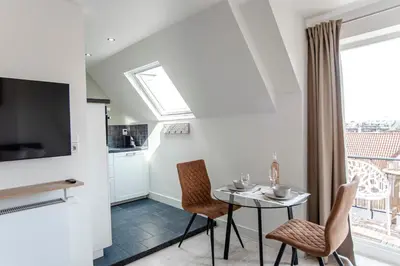 a kitchen and dining room with a table and chairs at Sand & Dunes Apartment in Zandvoort