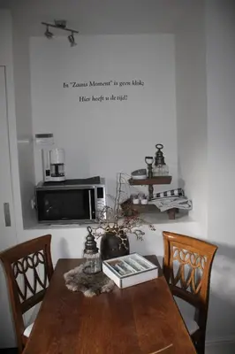 a kitchen with a wooden table with chairs and a microwave at Studio Bed and Breakfast Zaans Moment in Assendelft