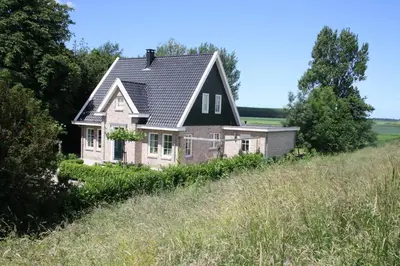 a house on a hill in a field at Studio Bed and Breakfast Zaans Moment in Assendelft