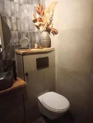 a bathroom with a toilet and a vase with a bird on it at Studio Bed and Breakfast Zaans Moment in Assendelft