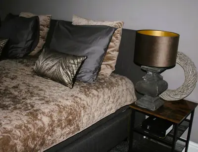 a bed with pillows and a lamp on a night stand at Studio Bed and Breakfast Zaans Moment in Assendelft
