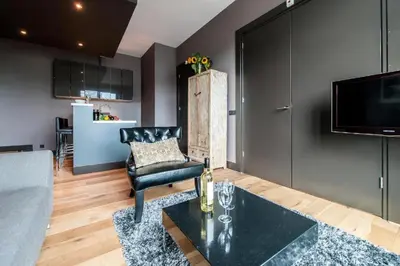 a living room with a table and a couch at Hotel Mosaic Apartments in Amsterdam