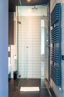 a bathroom with a shower with a glass door at Hotel Mosaic Apartments in Amsterdam
