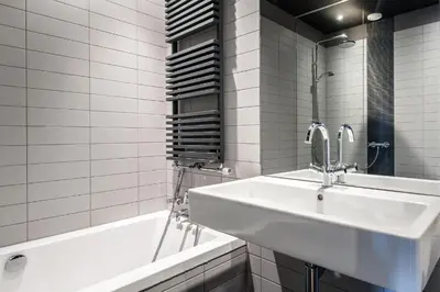 a white bathroom with a sink and a bath tub at Hotel Mosaic Apartments in Amsterdam