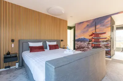 a bedroom with a large bed with a painting on the wall at Beach Villa & Studio in Zandvoort