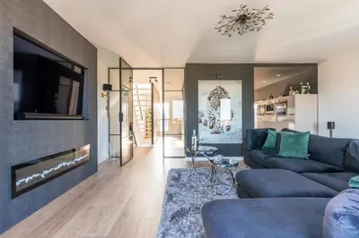 a living room with a couch and a tv at Beach Villa & Studio in Zandvoort