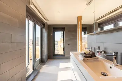 a bathroom with a large sink and a large window at Beach Villa & Studio in Zandvoort