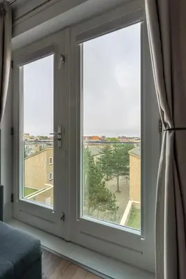 two windows in a room with a view of a city at Beach Villa & Studio in Zandvoort