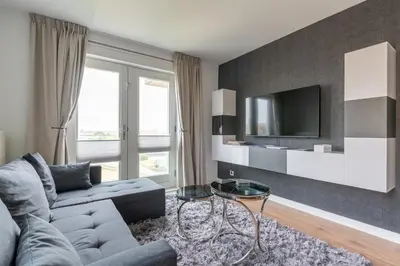 a living room with a couch and a tv at Beach Villa & Studio in Zandvoort