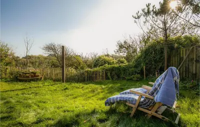 a chair sitting in the grass in a yard at Zeevilla Duinhorst in Bergen aan Zee
