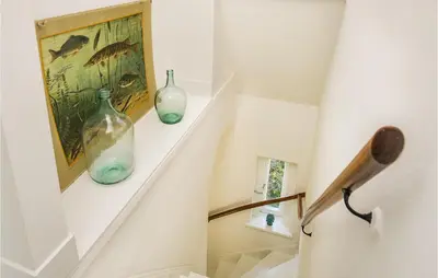 a staircase with two blue glass vases on a shelf at Zeevilla Duinhorst in Bergen aan Zee