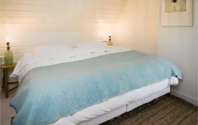 a bedroom with a bed with a blue blanket on it at Zeevilla Duinhorst in Bergen aan Zee