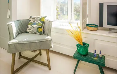 a chair in a room with a vase on a table at Zeevilla Duinhorst in Bergen aan Zee
