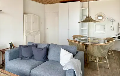 a living room with a blue couch and a table at Zwaluwnest in Bergen aan Zee