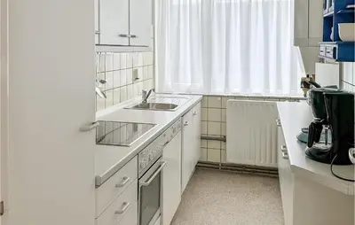 a white kitchen with a sink and a window at Zwaluwnest in Bergen aan Zee