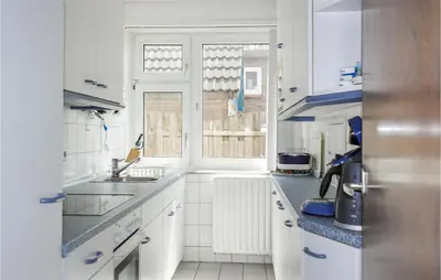 a white kitchen with a sink and a window at Duinennest in Bergen aan Zee