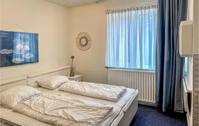 a small bedroom with a bed and a window at Duinennest in Bergen aan Zee