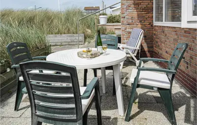 a white table and chairs on a patio at Duinennest in Bergen aan Zee