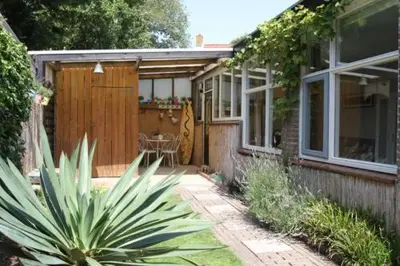 a house with a patio with a table and a fence at Studio Waves in Egmond aan Zee