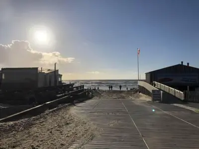 a boardwalk on a beach near the ocean at Studio Waves in Egmond aan Zee