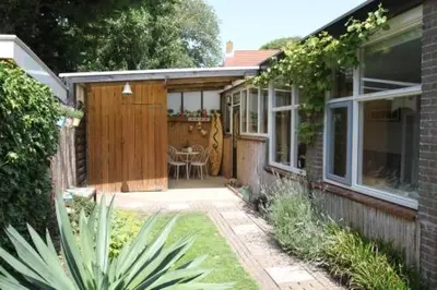 a house with a patio with a table in it at Studio Waves in Egmond aan Zee