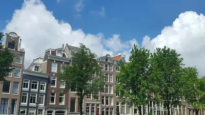 a row of buildings with trees in front of them at B&B Singel Suites in Amsterdam