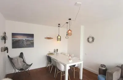 a living room with a white table and chairs at Appartementen aan zee in Egmond aan Zee