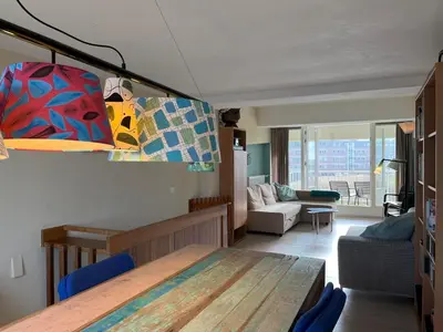 a living room with a table and a couch at Appartementen aan zee in Egmond aan Zee