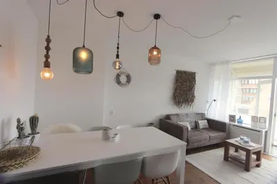 a living room with a table and a couch at Appartementen aan zee in Egmond aan Zee