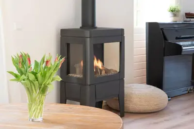 a fireplace in a living room with a vase of flowers at klaproos Bergen NH in Bergen